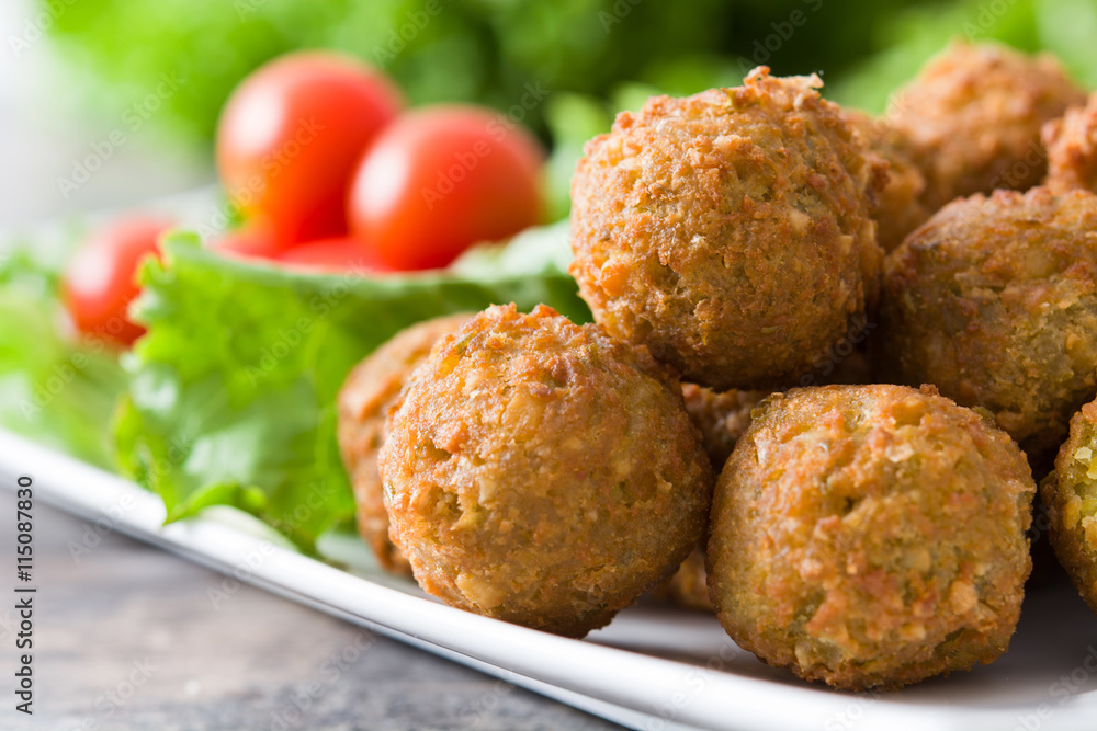 Vegetarian falafels and vegetables on a rustic wood

