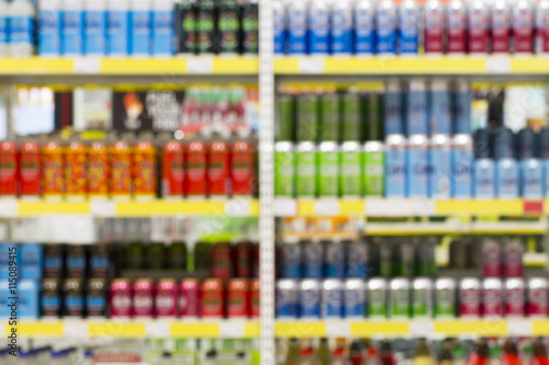 Blur of bottles of beer, cider and other alcohol drinks on Shelf in Supermarket Liquor Part