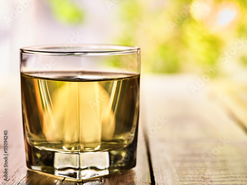Country drink. On wooden boards is glass with green transparent drink. A drink number one cold green tea. Country life. Light background.