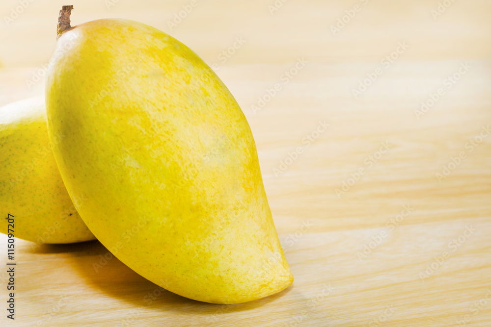 mangoes, yellow mangoes isolated on wood table background.