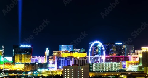 Las Vegas City Center Night Time Lapse Glow. a close up skyline shot of downtown las vegas nevada at night with glowing lights illuminating the night. Ferris wheel spinning.
