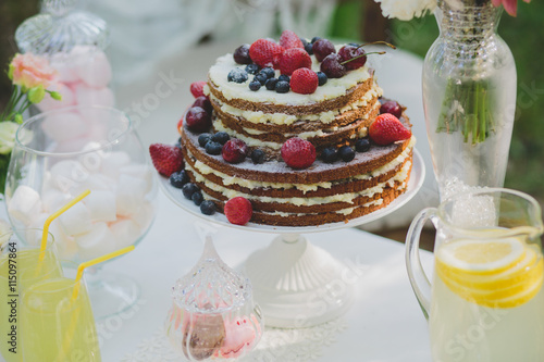 decorated sweet table for summer wedding picnic with sweets, cup