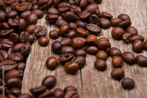 Coffee beans on wooden background. Brown coffee seeds. Old table with coffee grains. Imported coffee from India.