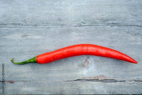 red hot chili pepper on a gray wooden background with empty copy space 