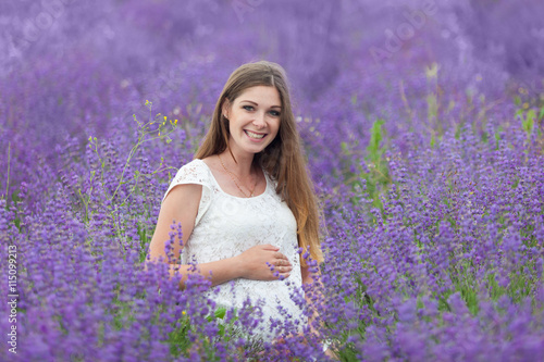 Fototapeta Naklejka Na Ścianę i Meble -  Lavender field and a happy pregnant woman