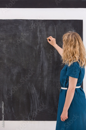 Young girl drawing on a black background. Business woman writting on the board. Teacher hand drawing on chalkboard. Education and idea concept.