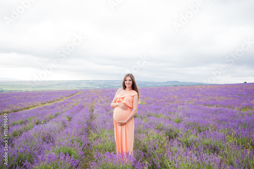 Fototapeta Naklejka Na Ścianę i Meble -  Lavender field and a happy pregnant woman
