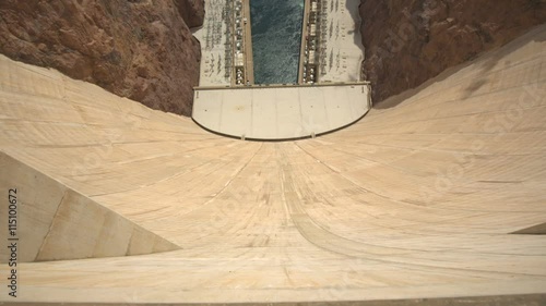View from Over the Edge of the Hoover Dam. camera moves over the edge of the Hoover Dam Wall looking down, then tilts up to show the memorial bridge
