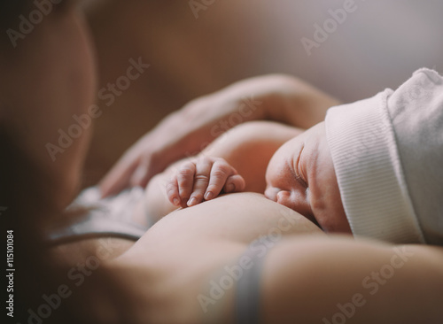 Mother holding her newborn child. Mom nursing baby Fototapet