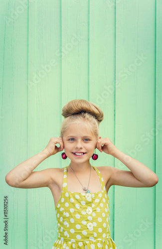 Beautiful girl holding cherries as earrings -style Rockabilly. photo