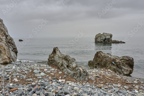 Fototapeta Naklejka Na Ścianę i Meble -  A rocky beach on the coast of the Aegean Sea in Greece.