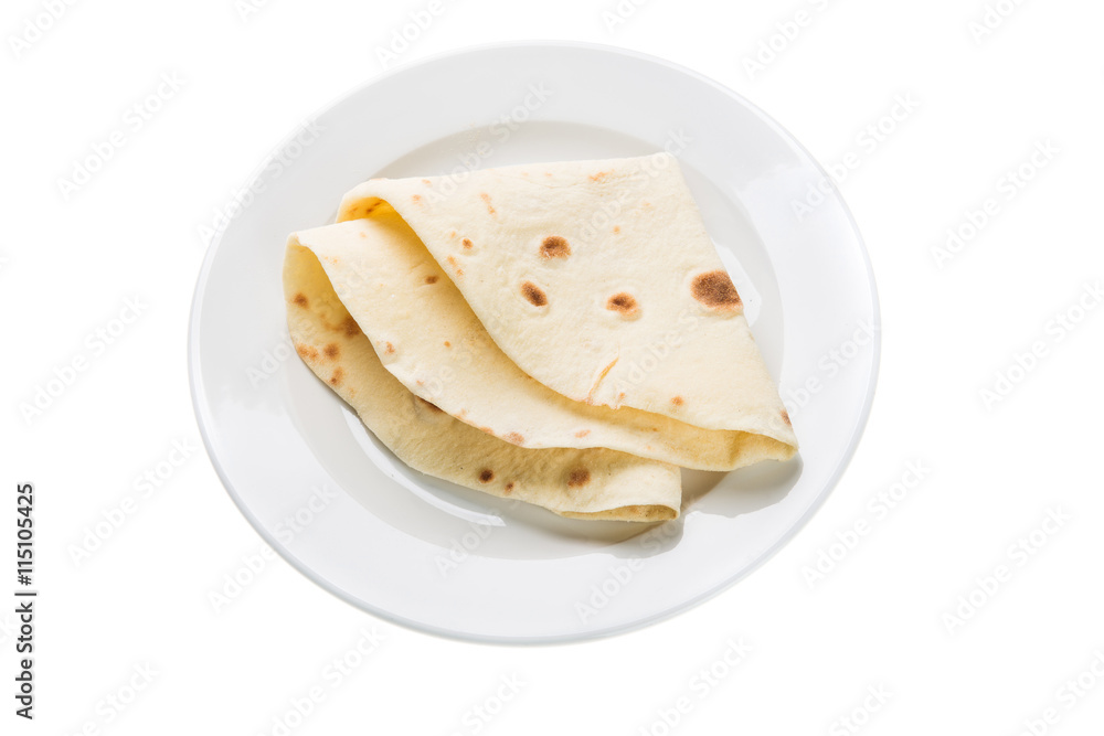 Wheat tortilla on plate isolated on white Wheat tortilla on plate isolated on white