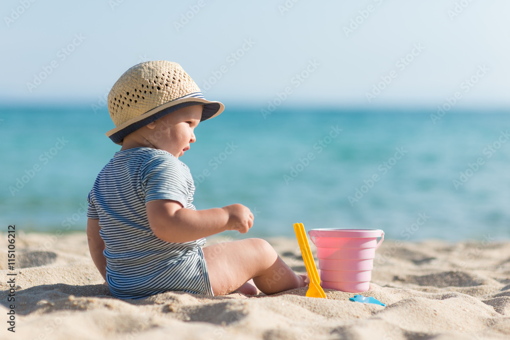 Boy toddler is playing with sand on the beach Boy toddler is playing with sand on the beach