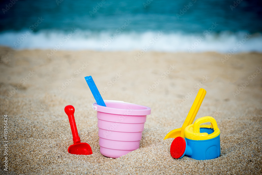 Children's beach toys - buckets, spade and shovel on sand on sunny day