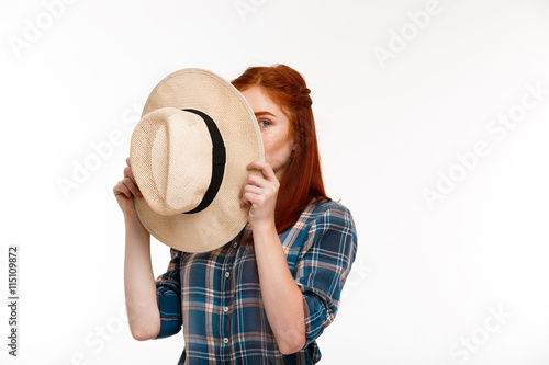 Portrait of beautiful ginger girl with hat over white background.