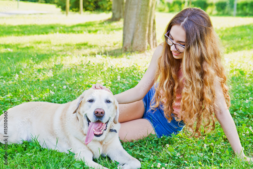 Girl playing with her labrador retriever dog in the park Girl playing with her labrador retriever dog in the park