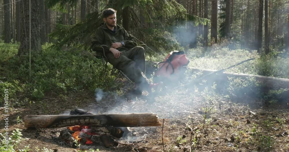 a man sits at a campfire a man sits at a campfire