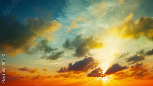 Tropical Sunset in Timelapse, with playful, puffy clouds drifting and building in bold colors of blue, orange, yellow and red. Video 4k