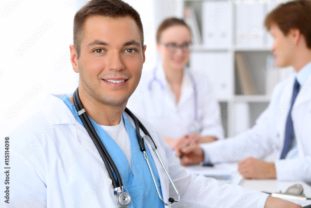 Cheerful smiling male doctor with medical staff at the hospital Cheerful smiling male doctor with medical staff at the hospital