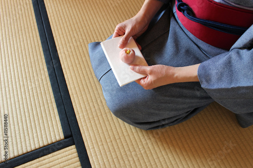 Kimono woman is eating pink cake at Japanese matcha tea ceremony room