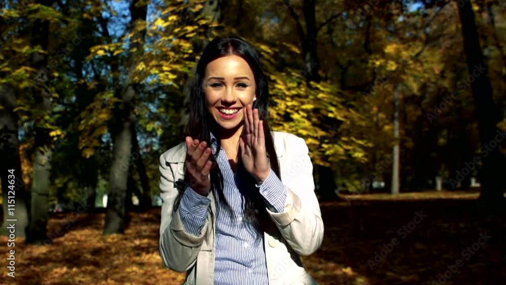 Slowmotion young beautiful happy woman stands in woods and applauds Slowmotion young beautiful happy woman stands in woods and applauds