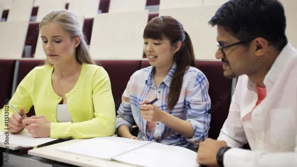 group of students with notebooks in lecture hall group of students with notebooks in lecture hall