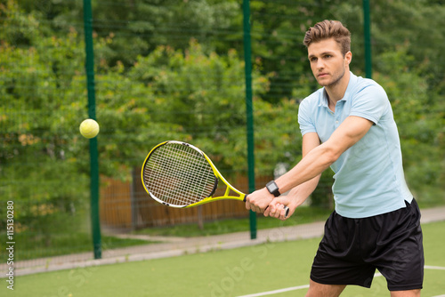 Cheerful male athlete playing tennis