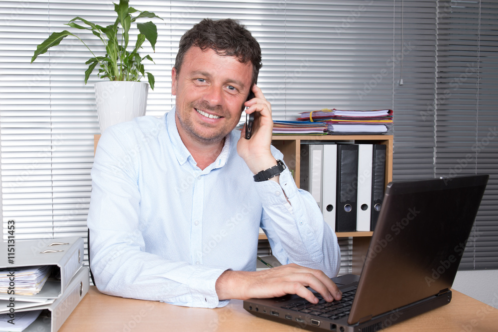 Businessman talking on mobile phone in office Businessman talking on mobile phone in office