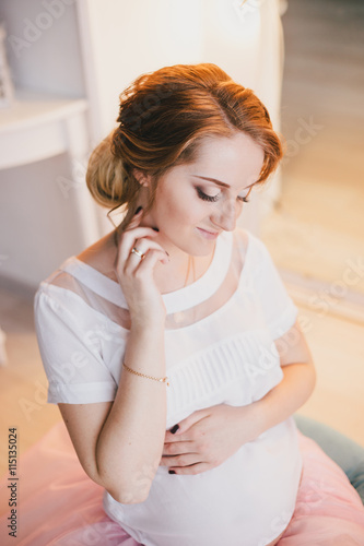 Young beautiful pregnant woman posing in a vintage interior