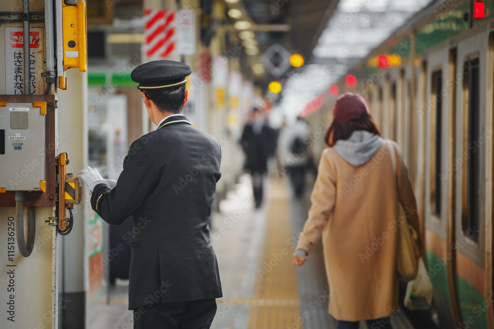 Obraz premium Niezidentyfikowany japoński konduktor na stacji kolejowej w Tokio w Japonii