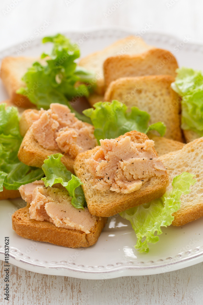 toasts with fish pate on white plate on white wooden background toasts with fish pate on white plate on white wooden background