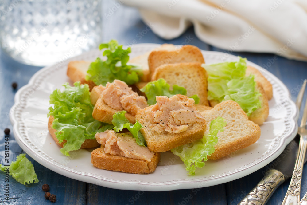 toasts with pate on white dish on blue background toasts with pate on white dish on blue background