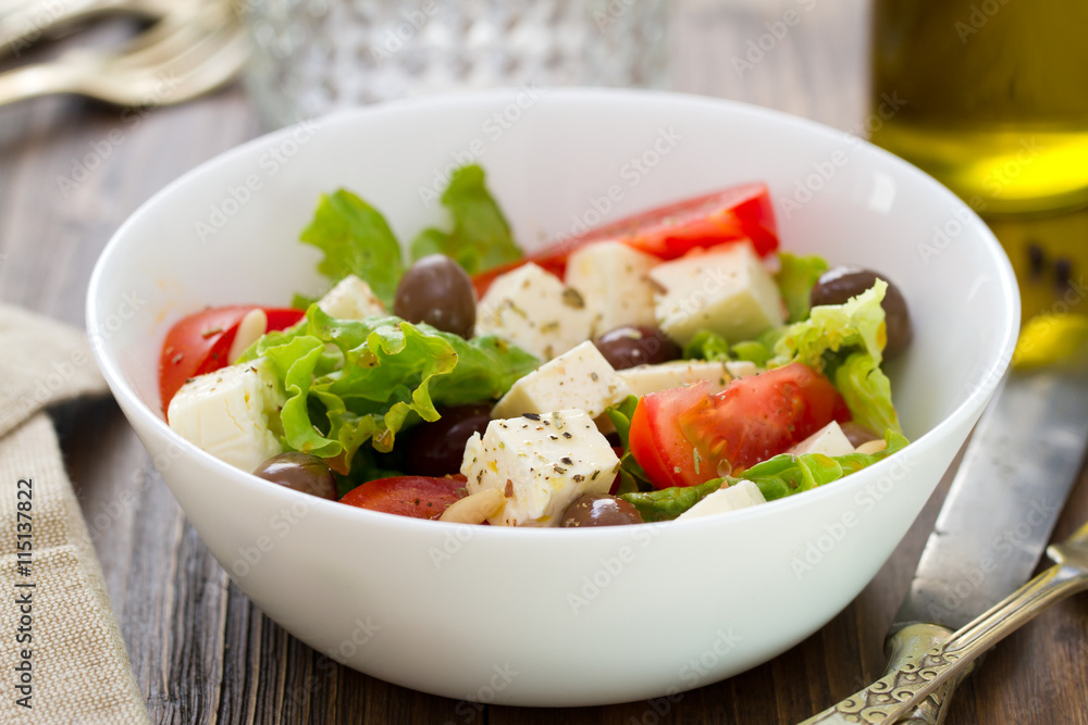 salad cheese with vegetables in white bowl on brown background salad cheese with vegetables in white bowl on brown background