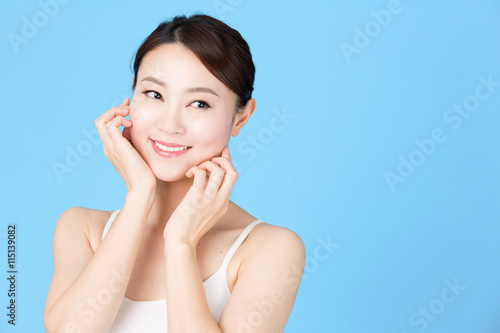 attractive asian woman isolated on blue background © taka