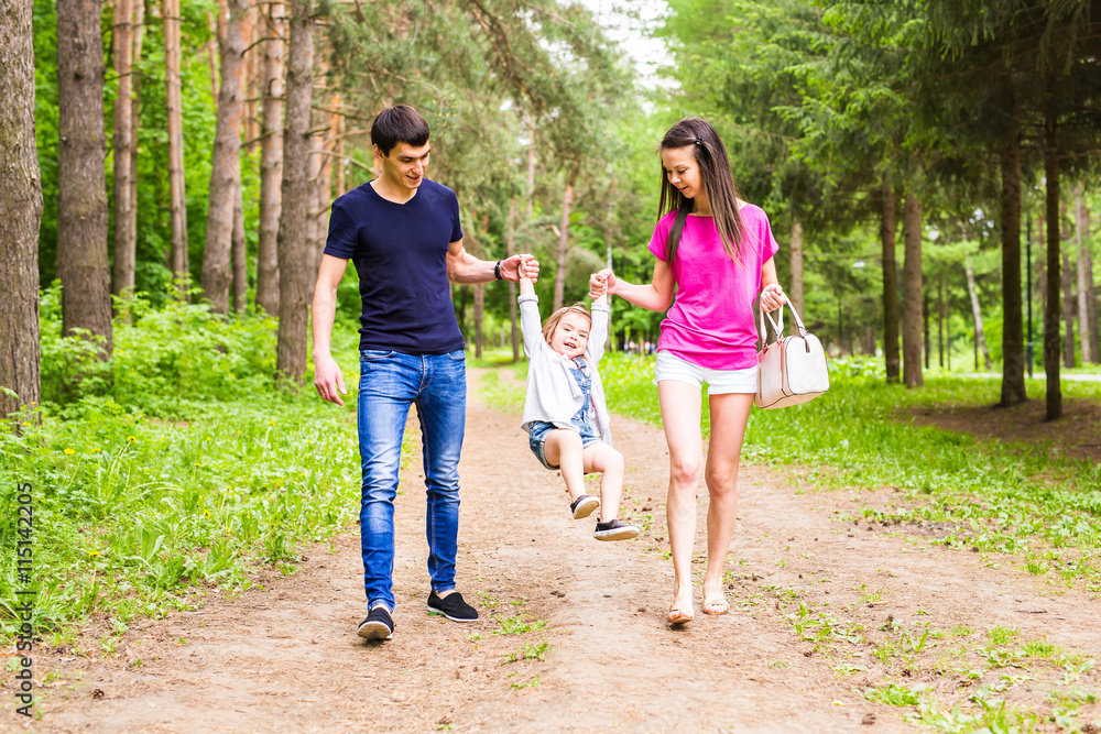 Happy young family spending time together outside in green nature.