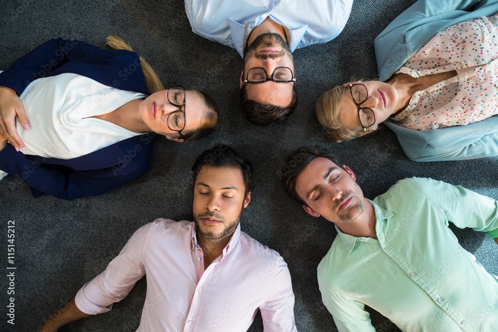 Business team with eyes closed lying on the floor 