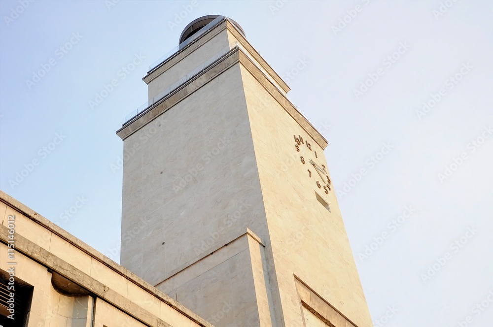 Obraz premium Architecture 30's facade detail with clock tower. Italy.