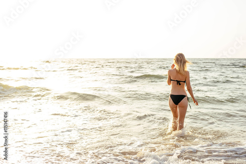 young beautiful female on beach enjoying vacation during sunset or sunrise 
