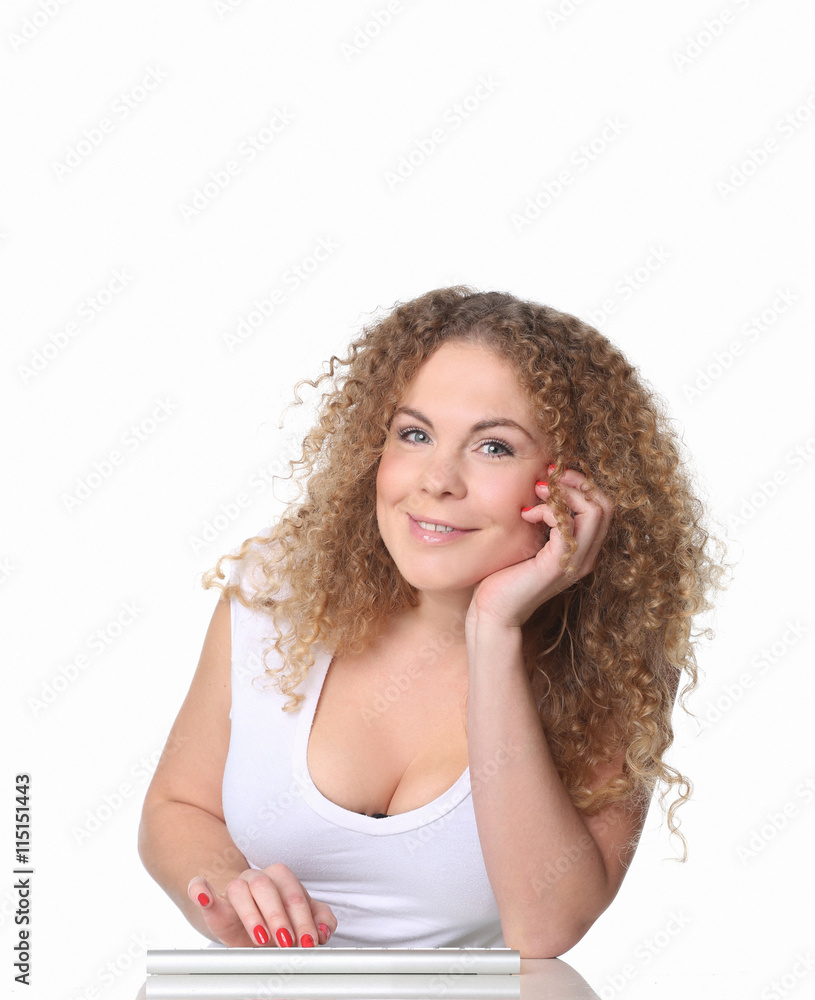 Smiling woman with red curly hair sitting at a desk typing on keyboard Smiling woman with red curly hair sitting at a desk typing on keyboard