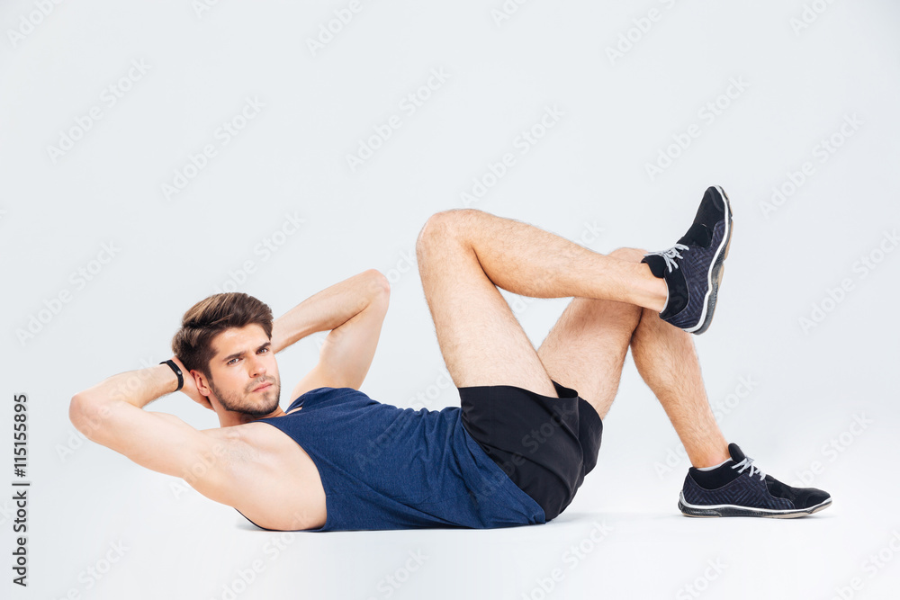 Handsome young man athlete working out and doing crunches Handsome young man athlete working out and doing crunches