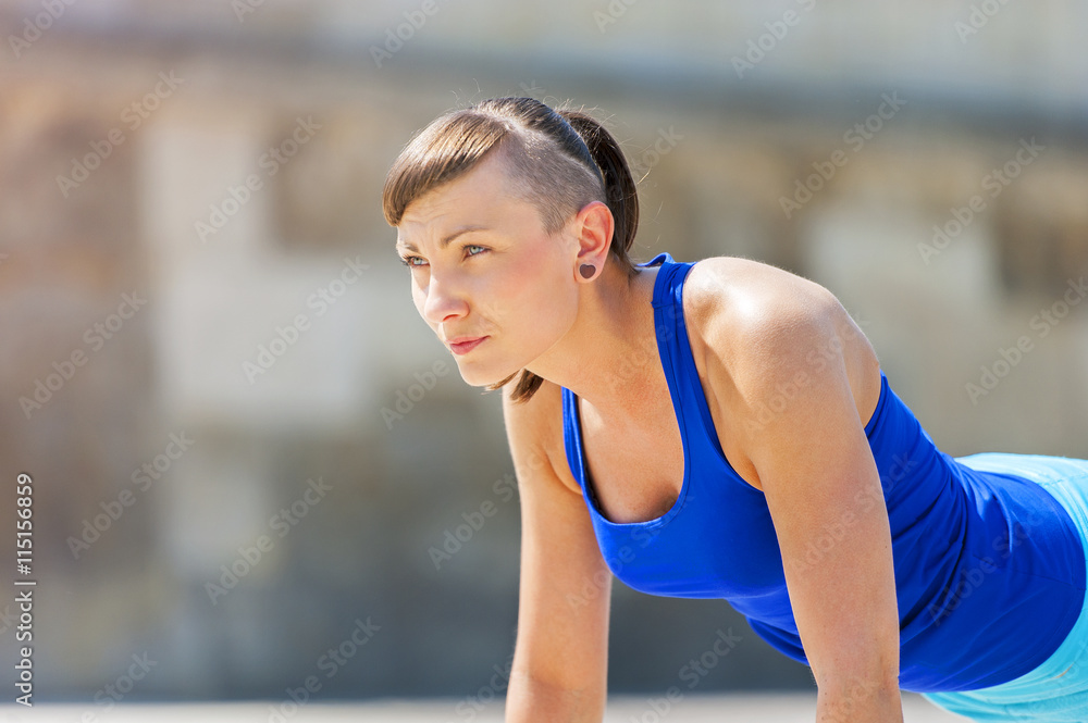Fototapeta premium Woman doing pushups outdoor.