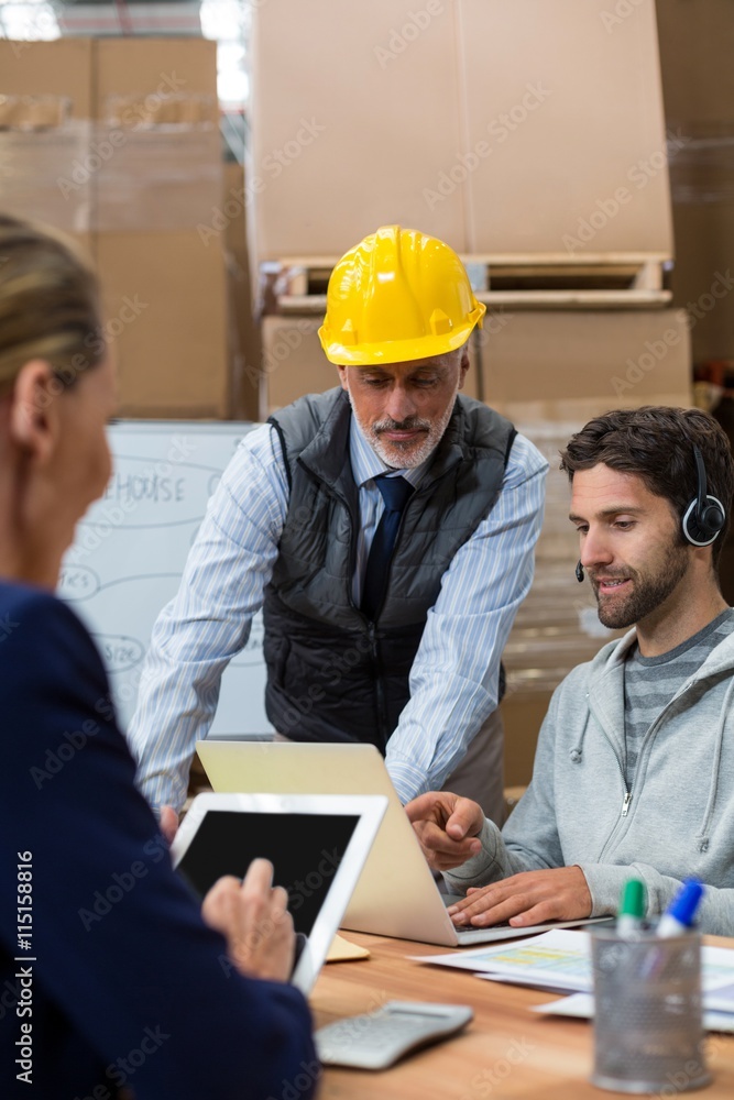Workers using digital devices in warehouse Workers using digital devices in warehouse