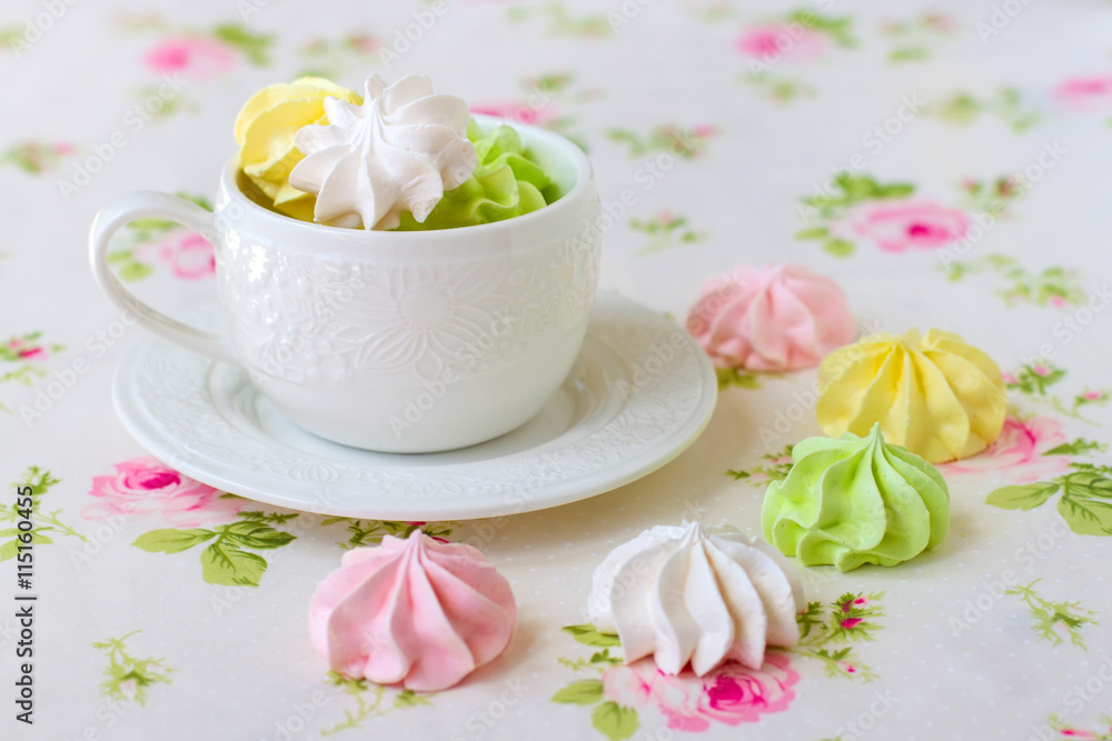 Colorful meringues in white tea cup