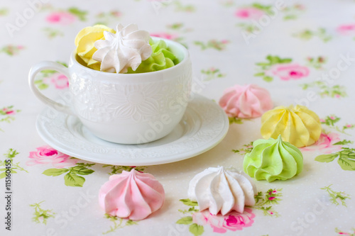 Colorful meringues in white tea cup