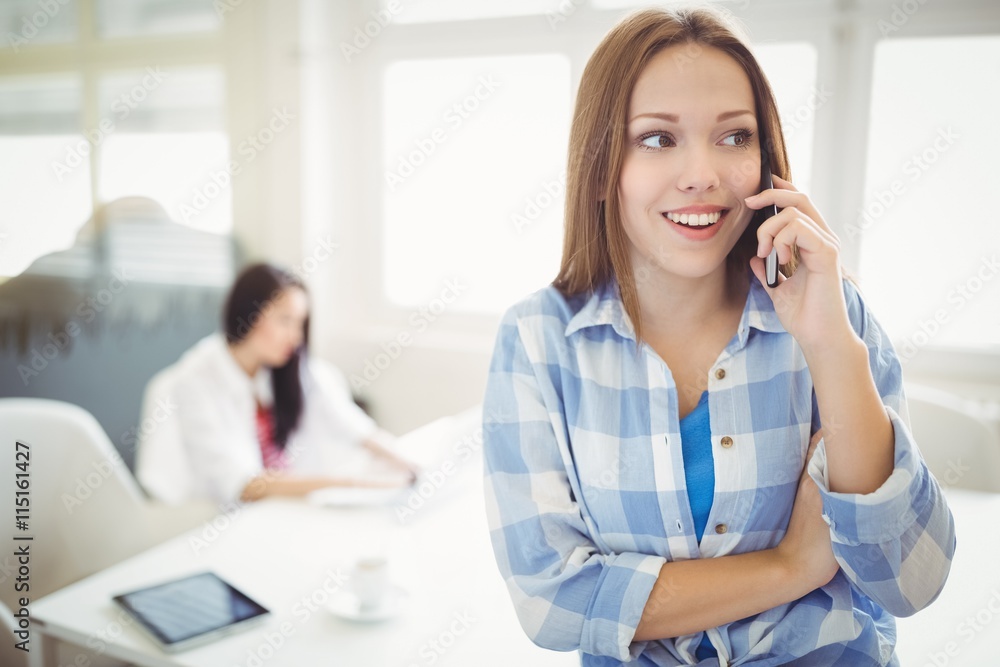 Businesswoman using phone with colleague Businesswoman using phone with colleague