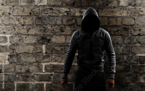 Mann mit einem Hoodie vor einer Mauer