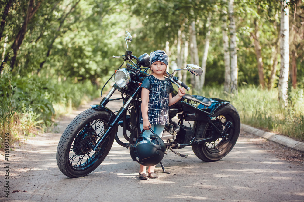 Obraz premium Little girl on a motorcycle.
