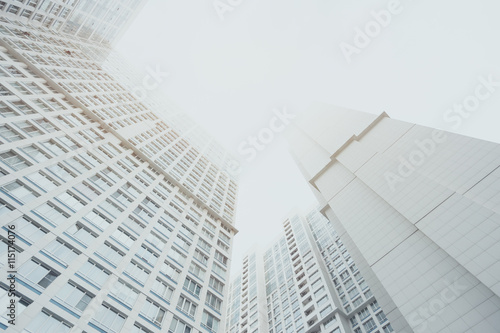 White contemporary residential skyscraper apartment building in Moscow on a cloudy day  two housing body  regular windows  view from bottom