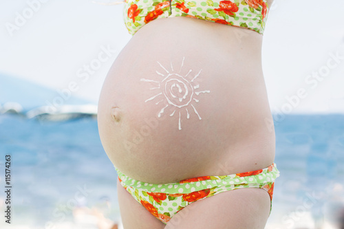 Sunscreen lotion on pregnant belly