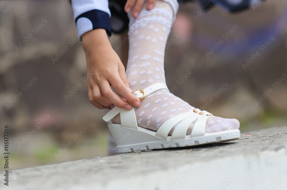 little girl putting on her sandals